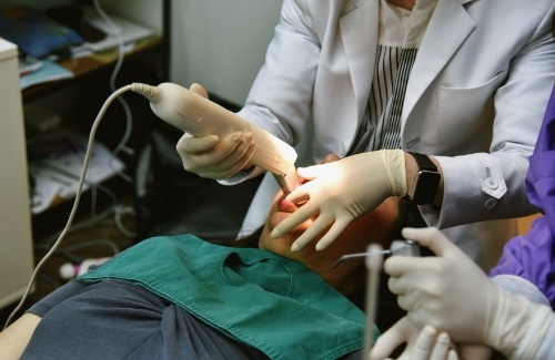 Dental patient leaning back being treated by dentist