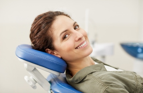 Woman leaning back in dental chair and smiling