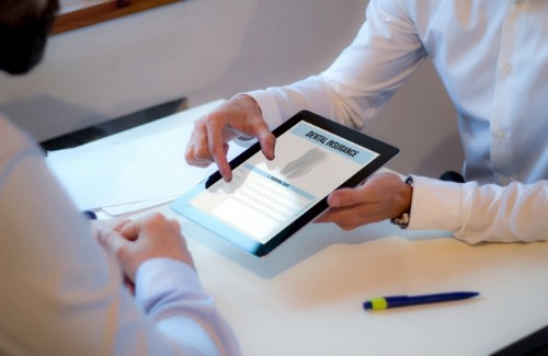 Showing patient dental insurance form on tablet