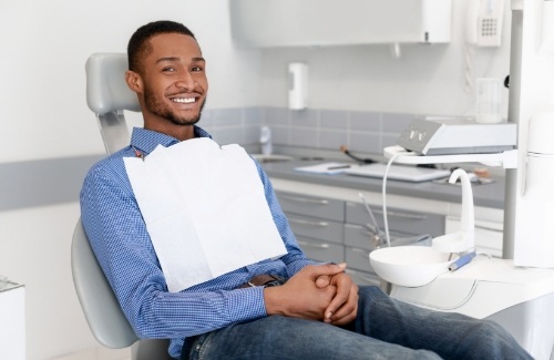 Male dental patient smiling with hands folded