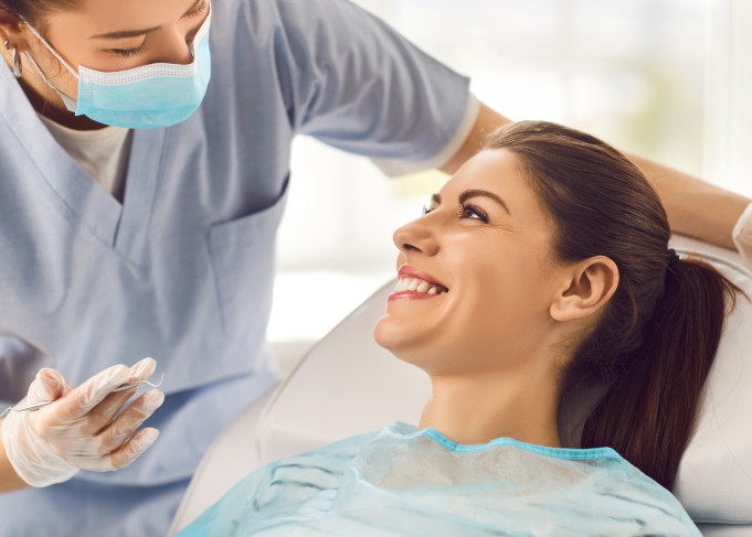 Female patient smiling and looking up at dentist