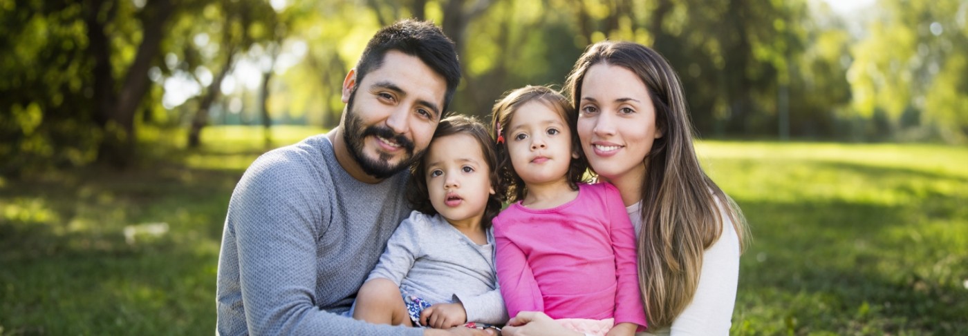 Family huddled together outside in field