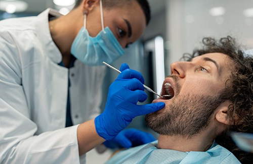 A dentist checking their patient’s mouth