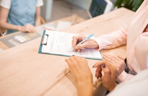 Close up of patient filling out a form