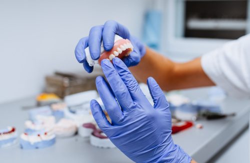 Dental implant and crown being placed in mouth