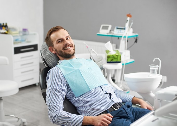 Male dental patient sitting back and smiling