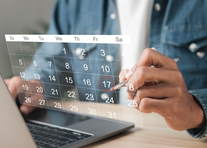 Person on laptop looking at a calendar