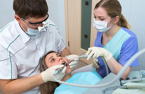 A dentist and hygienist treating a patient