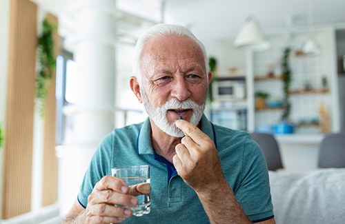 An older man taking a sedative pill before he visits his dentist