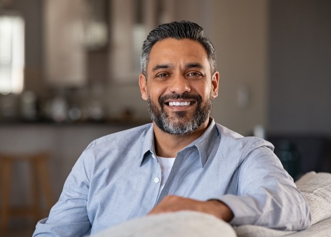 Bearded man sitting on couch and smiling